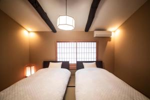 京都Rinn Nishiwakamatsu的有窗户的房间里有两张床 更多24张照片