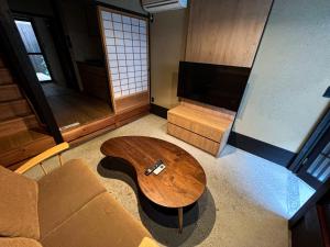 uma sala de estar com um sofá e uma mesa de centro em Rinn Rokujo Machiya em Quioto