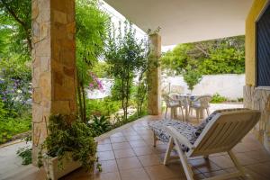 an outdoor patio with a table and chairs and trees at Villa Rita a 200m dal mare in I Bacini