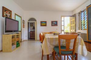 a dining room with a table and a television at Villa Rita a 200m dal mare in I Bacini
