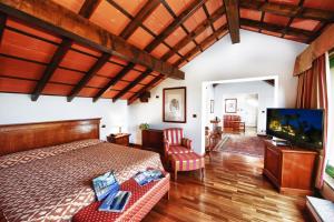 a bedroom with a bed and a flat screen tv at Relais Casali della Cisterna in Belgirate