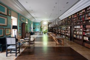 biblioteca con mesas, sillas y estanterías en Parador de Corias, en Cangas del Narcea