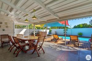 a patio with a table and chairs and a pool at Villa Honorine - Piscine privée - Saint-Gilles in Saint-Gilles-les Hauts