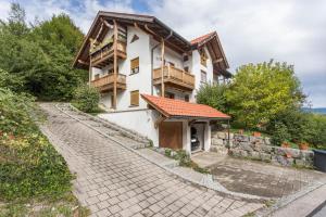 a house in the mountains with a cobblestone driveway at Ferienwohnung Chiemgau - erleben in Siegsdorf