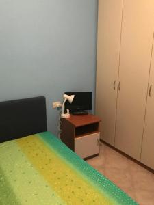 a bedroom with a bed and a desk with a television at villa Fiore in Borgo Diano San Pietro in Diano San Pietro