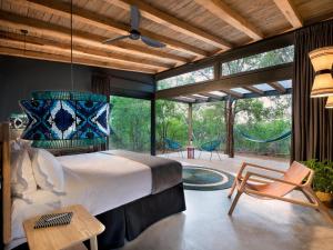 a bedroom with a large bed and a patio at Mbazo Safaris in Pilanesberg