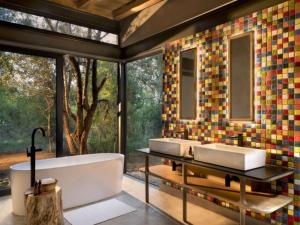 La salle de bains est pourvue de 2 lavabos et d'une baignoire. dans l'établissement Mbazo Safaris, à Pilanesberg