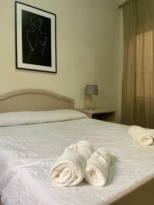 1 dormitorio con 1 cama con 2 toallas en Seafront Apartment with Balcony Overlooking Marina en Għajnsielem