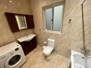 a bathroom with a toilet and a sink and a washing machine at Seafront Apartment with Balcony Overlooking Marina in Għajnsielem