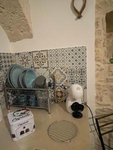 a kitchen counter with plates and appliances on a wall at Casa Giulia in Martina Franca