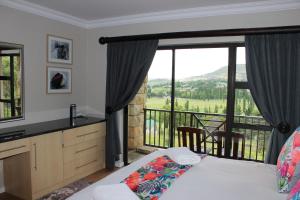 una camera con letto e un balcone con vista di Sunbird Haven Self-Catering Sleeps 8 a Clarens