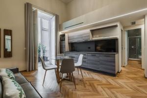 uma sala de estar com uma mesa e uma grande televisão em Ferrini Home - Riso 80 em Catânia