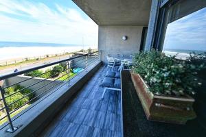 a balcony with chairs and a view of the beach at 30 Degrees Beach Apartment Umdloti in Umdloti