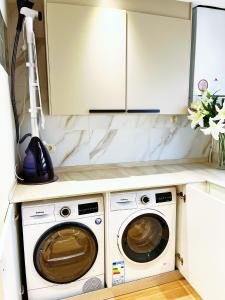 una cocina con lavadora y secadora en una encimera en Cheerful Townhouse Center Sitges 5 bedrooms Pool and Terrace, en Sitges