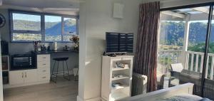 een kamer met een keuken, een bureau en een raam bij Modern Solar powered 1 bed studio apartment with amazing views in Plettenbergbaai