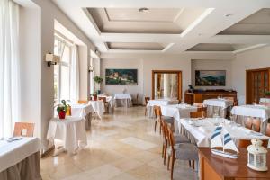 une salle à manger avec des tables et des chaises blanches dans l'établissement Parador de Jávea, à Jávea