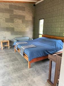 a bedroom with a bed and a couch in it at Forest Guesthouse in Ban Don Muang