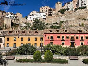 a row of colorful buildings in front of a city at Hostal Posada Huecar in Cuenca