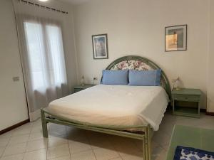 a bedroom with a large bed with blue pillows at Villa Isolella in Campese