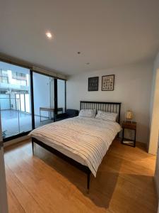 a bedroom with a large bed and a large window at Beachside Sunshine Lifestyle-great price-entire aprt at Port Melbourne in Melbourne