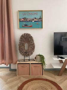 een woonkamer met een tv en een tafel bij .Surfin' La Chaume. in La Chaume