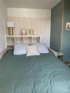 1 cama grande en un dormitorio con manta verde en .Surfin' La Chaume., en La Chaume