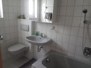 uma casa de banho branca com um lavatório e um WC em Ferienwohnung Toni em Freyung