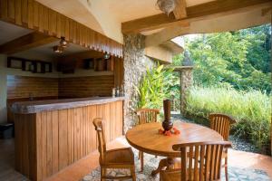 un patio con mesa de madera y sillas en Yoga Maya Villa, en Gianyar