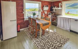 una cucina con tavolo, sedie e frigorifero di Amazing Home In Sortland With 3 Bedrooms And Wifi a Flesnes