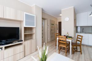 a living room with a kitchen and a dining room at Czarnieckiego Apartment with Balcony Poznań by Renters in Poznań