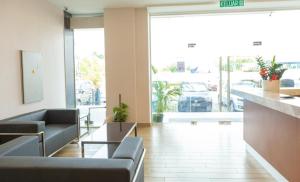 a lobby with couches and a large glass door at THE CROWN HOTEL @ KLIA in Sepang