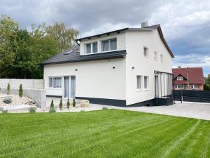 una casa blanca con césped verde en Csatári Ház - Szekszárd, en Szekszárd