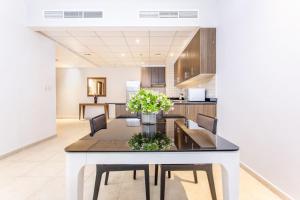 a kitchen and dining room with a table and chairs at Icon Casa Living - Classy High Floor - Elite Residence in Dubai