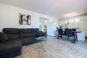 ein Wohnzimmer mit einem Sofa und einem Tisch in der Unterkunft Villa La Palmera in Cambrils