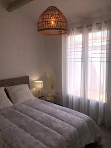 a bedroom with a bed and a large window at Maison au cœur de la La Palmyre in Les Mathes