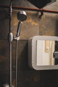 a shower head and a mirror on a wall at Viva La Vida - Jongno Hanok Private House in Seoul +74 photos