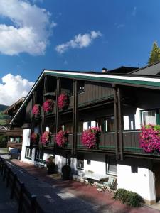 a building with potted plants and flowers on it at Haus am Bach in Kirchberg in Tirol