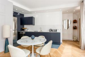 a kitchen and dining room with a table and chairs at Reva Suites in Paris