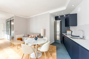 a kitchen with a table and chairs in a room at Reva Suites in Paris