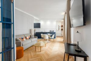 a living room with a couch and a table at Reva Suites in Paris