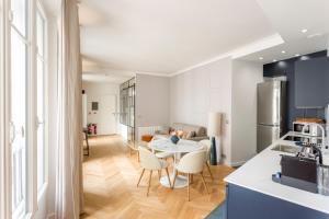 a kitchen and living room with a table and chairs at Reva Suites in Paris