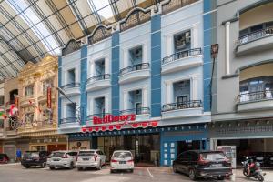 un gran edificio con coches estacionados en un estacionamiento en RedDoorz Plus near Ramayana Pematangsiantar, en Pematangsiantar