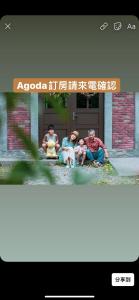 un grupo de tres personas sentadas frente a un edificio en 麵包樹舍 Breadfruit B&B, en Guangfu