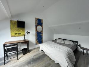 a bedroom with a bed and a desk and a television at Les paddocks du dock I - Appart tout confort in Calais