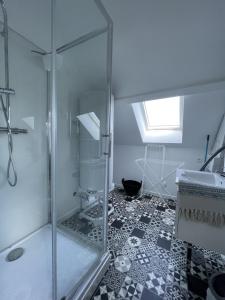 a bathroom with a glass shower and a black and white floor at Les paddocks du dock I - Appart tout confort in Calais