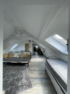 a room with several beds in a attic at Les paddocks du dock I - Appart tout confort in Calais