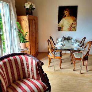 ein Esszimmer mit einem Tisch, Stühlen und einem Gemälde in der Unterkunft Einzigartiges Studio "Antico und Arte" am Strand von Tegna nur 5min von Ascona entfernt in Tegna