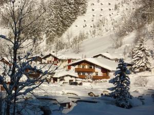 a snow covered mountain with a lodge in the background at Haus Christopherus in Klösterle