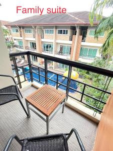 a balcony with a table and chairs and a swimming pool at Thalassa pool Kata Beach in Kata Beach