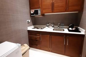 a small kitchen with a sink and a microwave at شقق نيروز ان للوحدات المخدومة in Jeddah